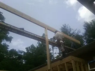 Carpenter setting a ridge beam over a new addition frame — Ice Dam Removal by Roofing Brothers in Canyonville