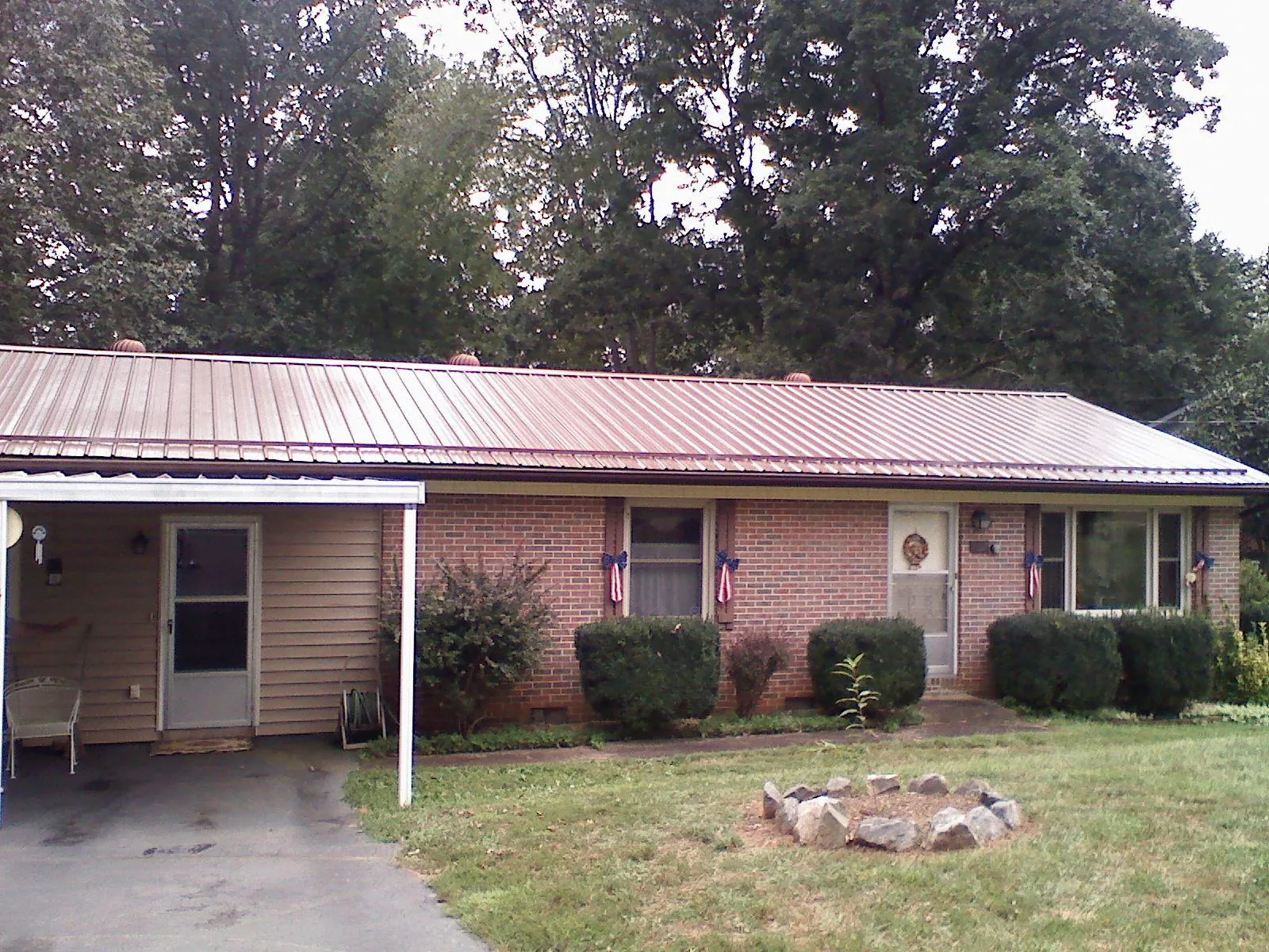 Bronze metal roof and carport on a brick ranch home — Roof Repair work by our crew in Canyonville